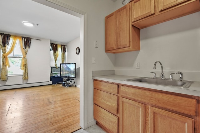 kitchen with light hardwood / wood-style floors, sink, and a baseboard radiator