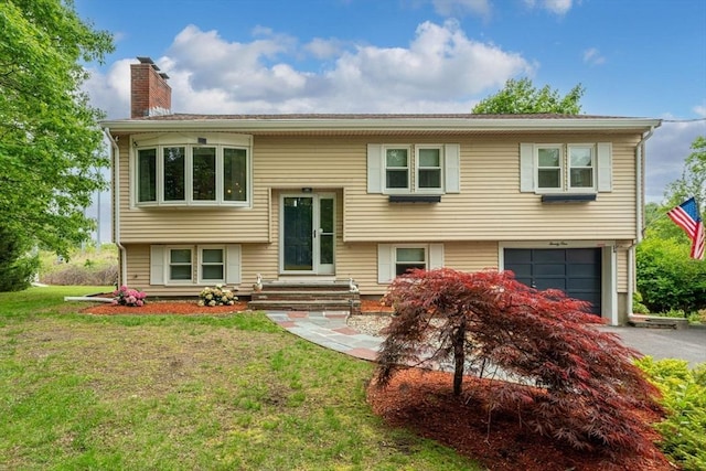 21 Wilhelmina Ave, Burlington, MA 01803 - split foyer home featuring a chimney, driveway, an attached garage, and a front lawn