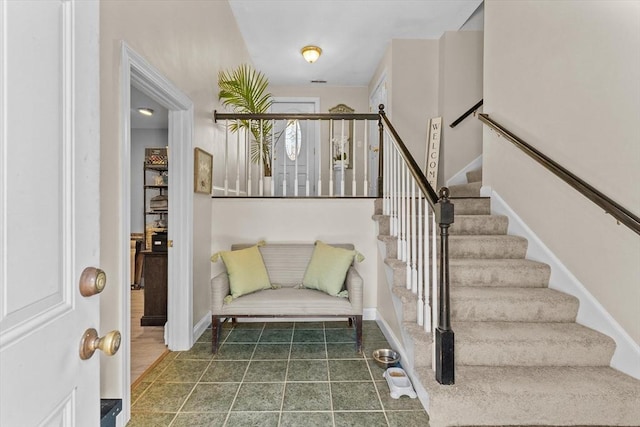 entrance foyer featuring tile patterned flooring, stairway, and baseboards