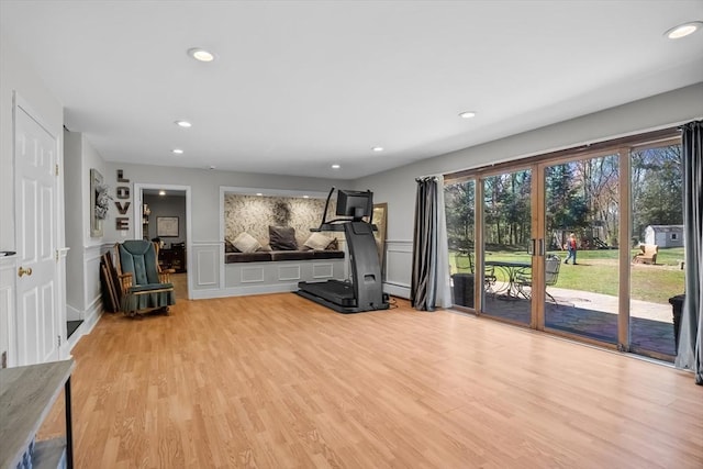 workout room with light wood-type flooring, a decorative wall, recessed lighting, and a baseboard heating unit
