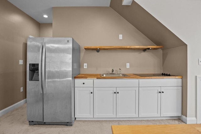kitchen with stainless steel fridge with ice dispenser, open shelves, a sink, black electric cooktop, and lofted ceiling