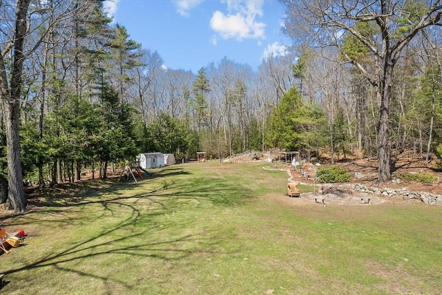 view of green lawn featuring a shed and an outdoor structure