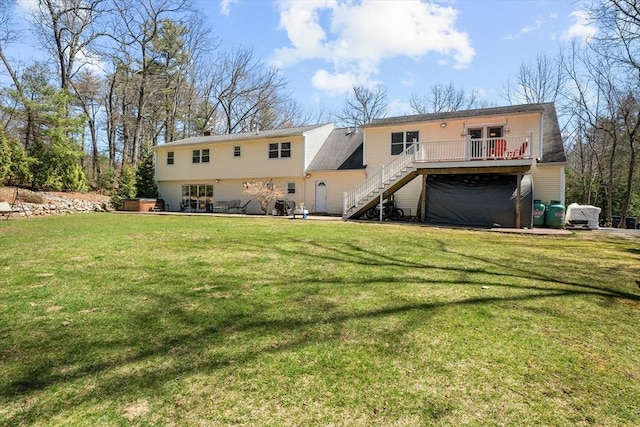 back of property featuring stairs, a wooden deck, a yard, and a garage