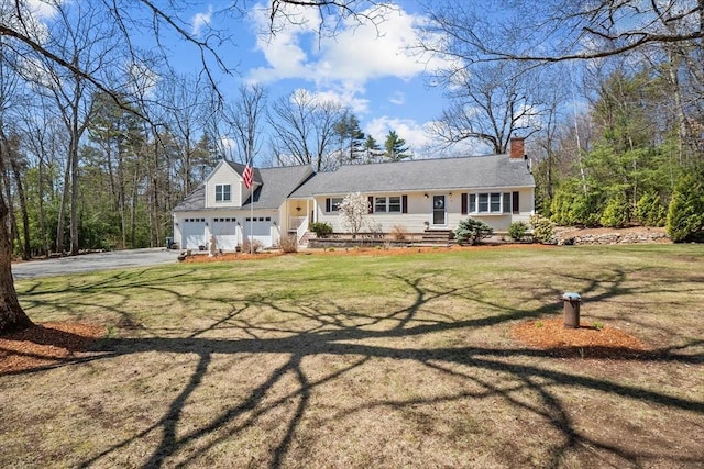 view of front of home with driveway, an attached garage, a front lawn, and a chimney