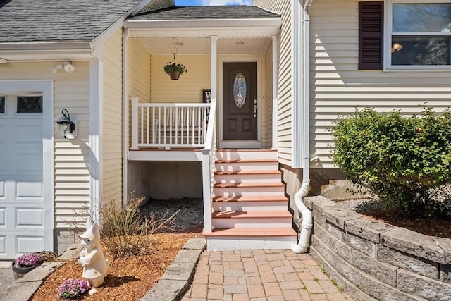 property entrance with a shingled roof, covered porch, and an attached garage