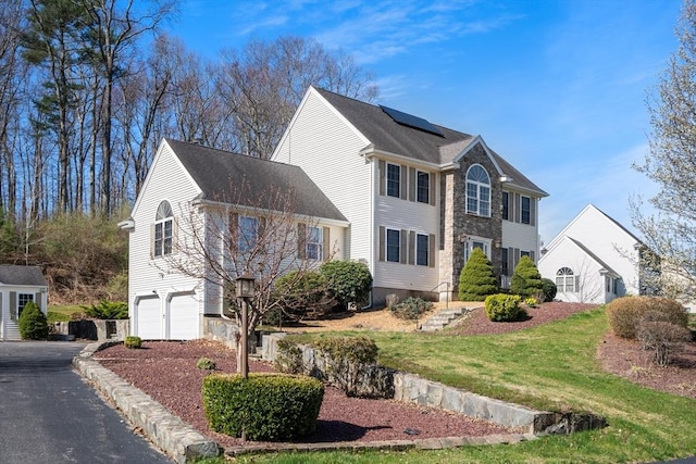 3 Jasmine Dr, Oxford, MA 01540 - view of front of home with a front lawn, aphalt driveway, stone siding, a garage, and solar panels