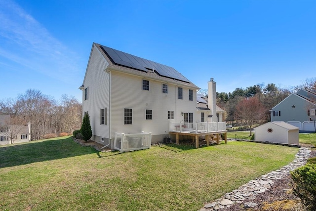 3 Jasmine Dr, Oxford, MA 01540 - back of property with roof mounted solar panels, a lawn, a wooden deck, and a chimney