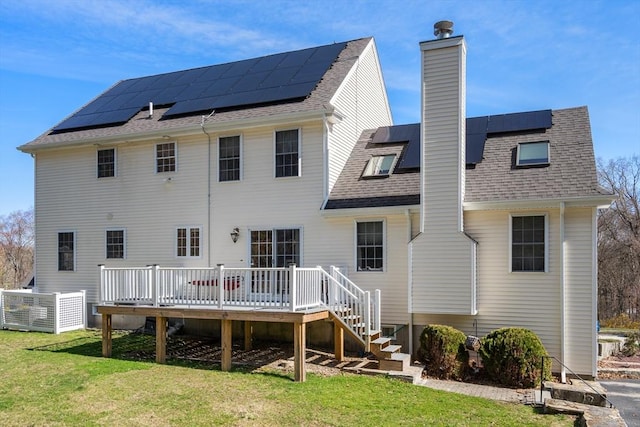 3 Jasmine Dr, Oxford, MA 01540 - back of house with a chimney, a lawn, a shingled roof, a deck, and roof mounted solar panels