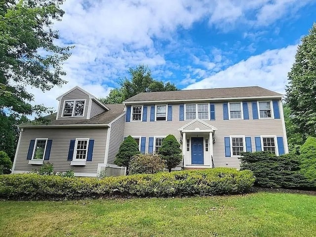 colonial inspired home featuring a front lawn