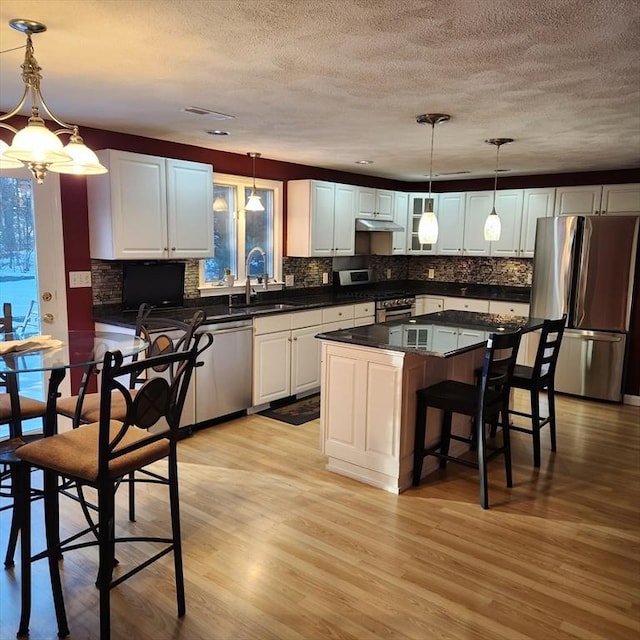 kitchen with pendant lighting, appliances with stainless steel finishes, and white cabinets