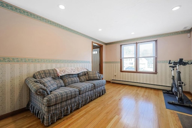 living room with wallpapered walls, wood-type flooring, and a wainscoted wall