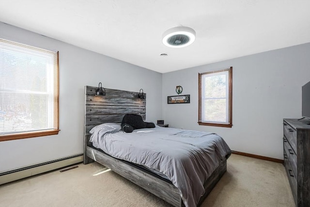 bedroom with baseboards, baseboard heating, and light colored carpet