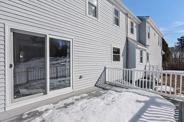 view of snow covered exterior featuring a wooden deck