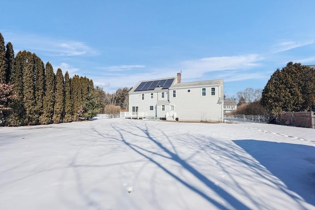 rear view of property featuring fence and a chimney