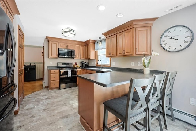 kitchen with stainless steel appliances, a peninsula, visible vents, dark countertops, and a kitchen bar