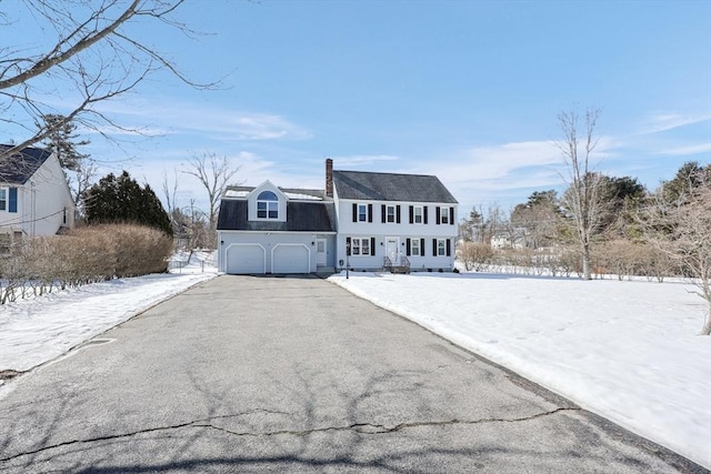 view of front facade featuring aphalt driveway and a chimney