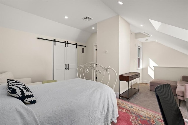 bedroom with lofted ceiling with skylight and a barn door