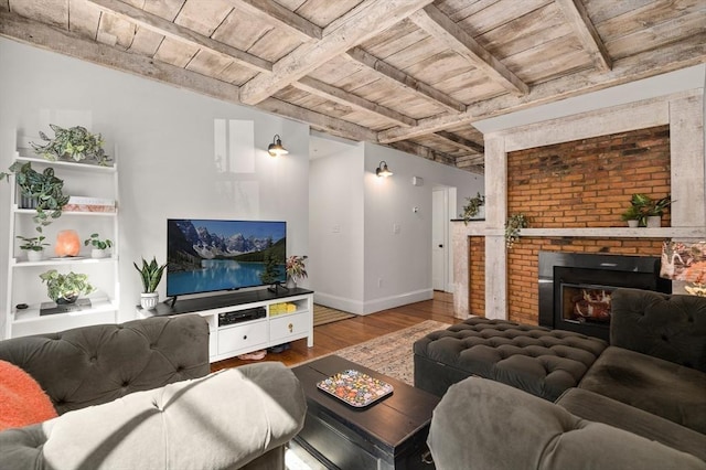 living room with beamed ceiling, a brick fireplace, wood-type flooring, and wood ceiling