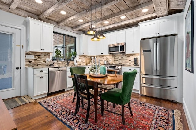 kitchen with stainless steel appliances, white cabinets, decorative light fixtures, and wooden ceiling