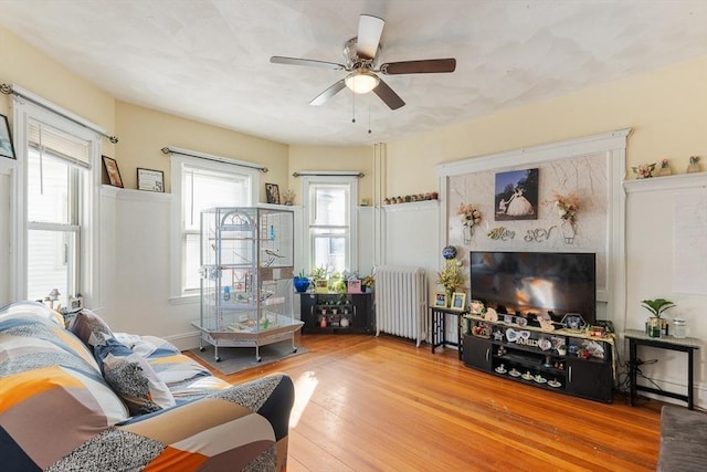 living room featuring hardwood / wood-style flooring, radiator heating unit, and ceiling fan