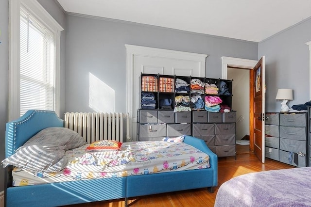 bedroom featuring hardwood / wood-style flooring and radiator