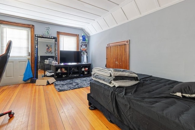 bedroom with hardwood / wood-style flooring and lofted ceiling