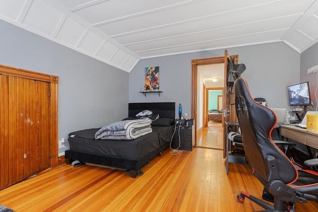 bedroom with lofted ceiling and wood-type flooring