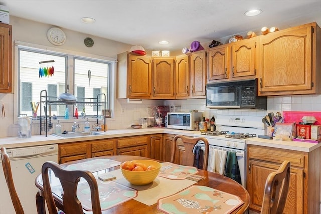 kitchen with sink, backsplash, and white appliances