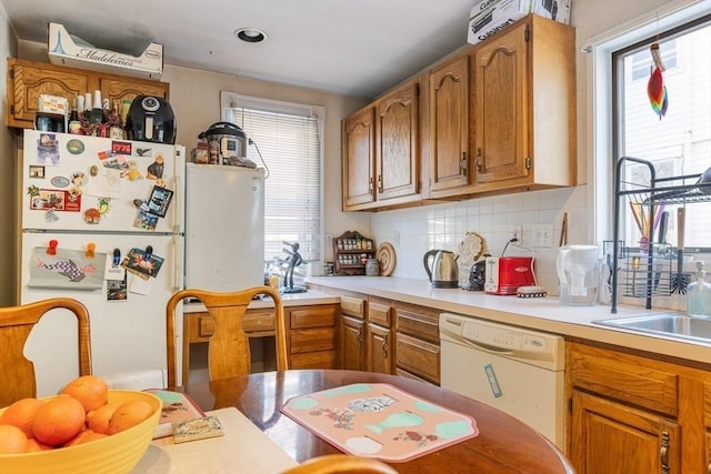 kitchen with white appliances, a healthy amount of sunlight, and decorative backsplash