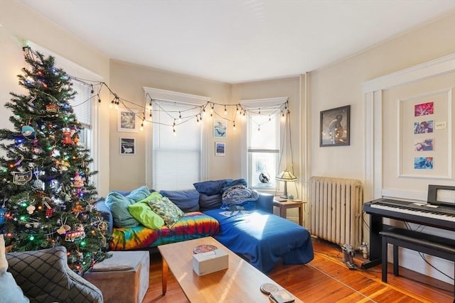 sitting room with radiator heating unit and wood-type flooring