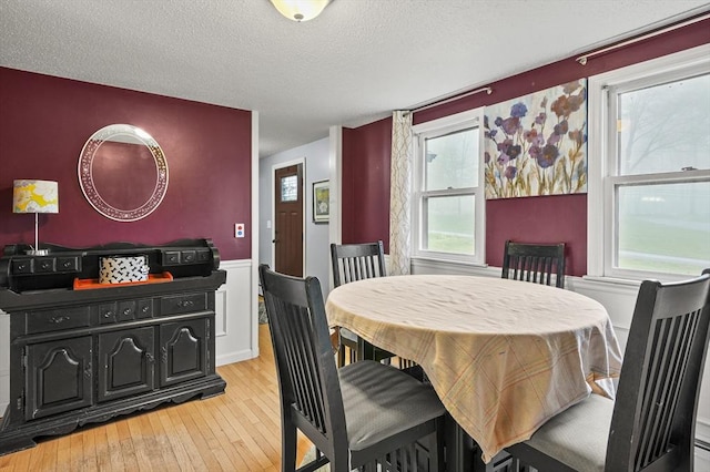 93 Lincoln Ave, Ashburnham, MA 01430 - dining room with light wood-style floors, a textured ceiling, and a wainscoted wall