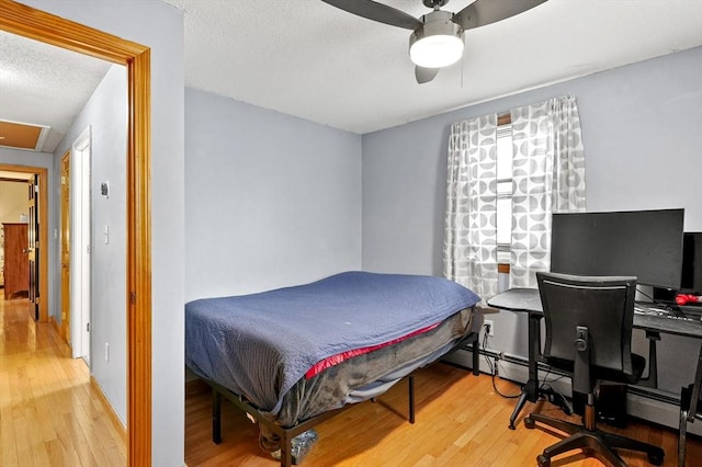 93 Lincoln Ave, Ashburnham, MA 01430 - bedroom with wood-type flooring, a desk, a textured ceiling, a ceiling fan, and a baseboard heating unit