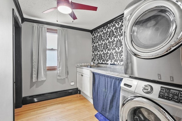 93 Lincoln Ave, Ashburnham, MA 01430 - laundry area featuring stacked washing machine and dryer, ornamental molding, a textured ceiling, ceiling fan, and light wood-style floors