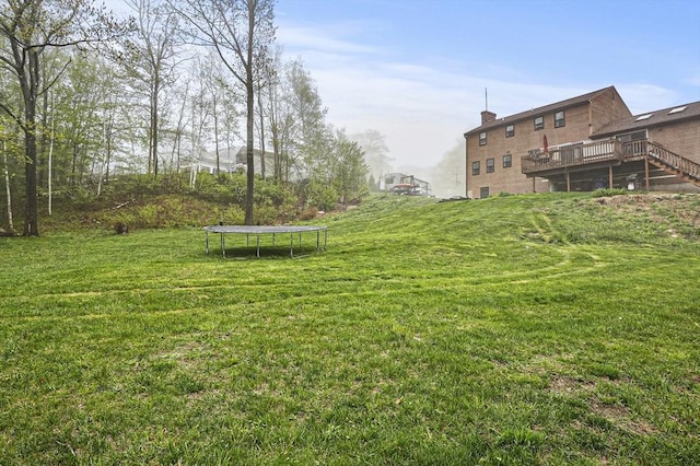 93 Lincoln Ave, Ashburnham, MA 01430 - view of green lawn featuring a trampoline and a deck