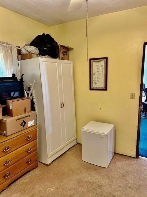 bedroom with ceiling fan and fridge