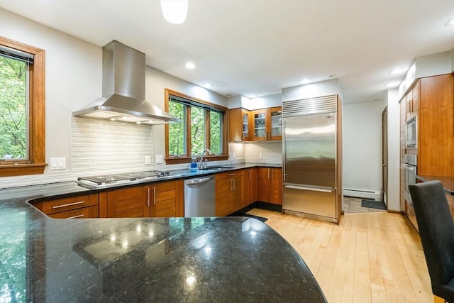 21 Birch Ln, Northampton, MA 01062 - kitchen with appliances with stainless steel finishes, wall chimney exhaust hood, a baseboard heating unit, brown cabinetry, and plenty of natural light
