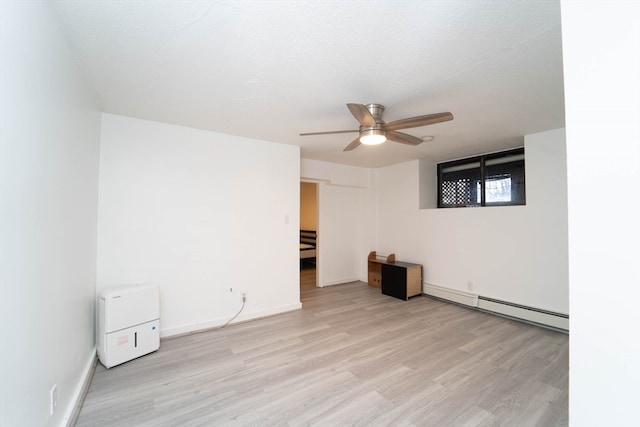 interior space featuring a baseboard heating unit, light hardwood / wood-style floors, ceiling fan, and a textured ceiling