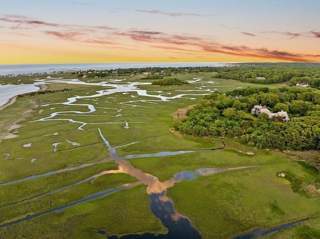 aerial view at dusk featuring a water view