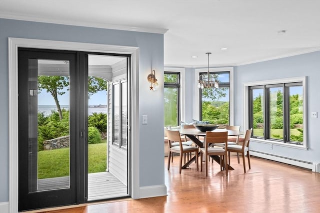 doorway featuring baseboard heating, crown molding, a notable chandelier, and hardwood / wood-style flooring