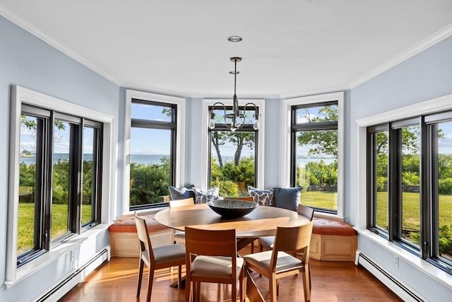 sunroom with a notable chandelier, plenty of natural light, and a baseboard heating unit