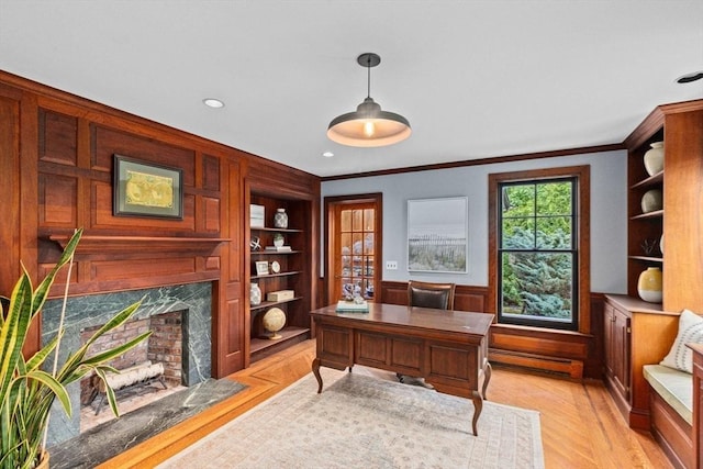 office area with baseboard heating, crown molding, and a fireplace