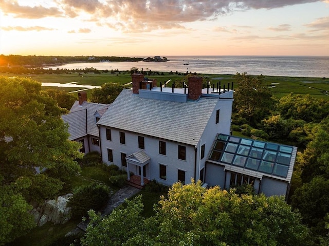 aerial view at dusk featuring a water view