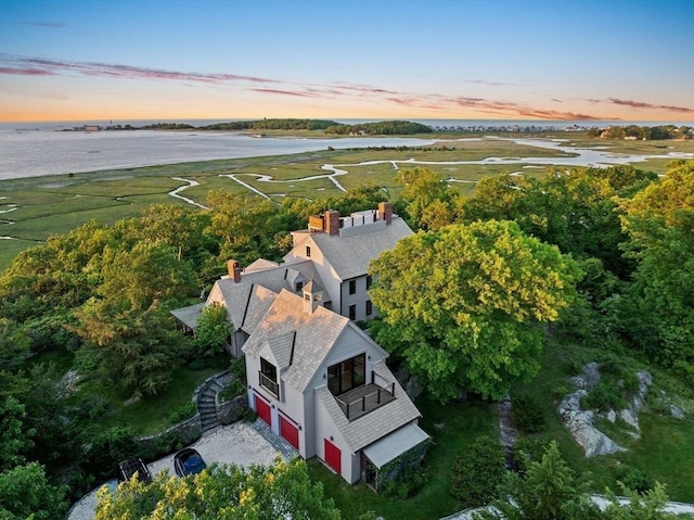 aerial view at dusk featuring a water view