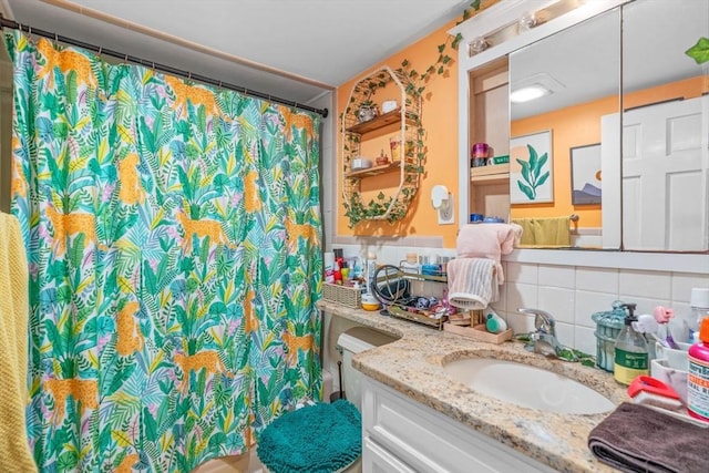 bathroom featuring a shower with shower curtain, decorative backsplash, and vanity