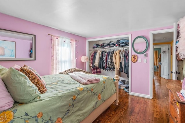 bedroom featuring a closet, wood finished floors, and baseboards