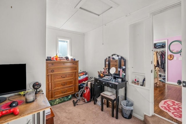 carpeted bedroom featuring attic access, a spacious closet, and wood finished floors