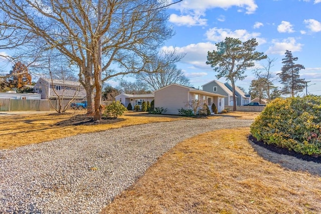 view of side of home with fence and a yard