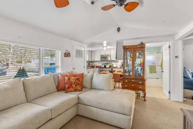 living area with light carpet, ceiling fan, and lofted ceiling