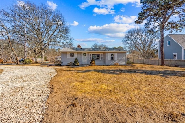 ranch-style house featuring fence and a front lawn