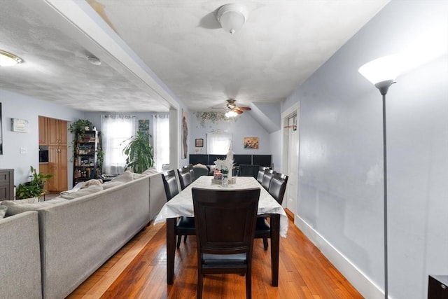 dining space with hardwood / wood-style floors and ceiling fan